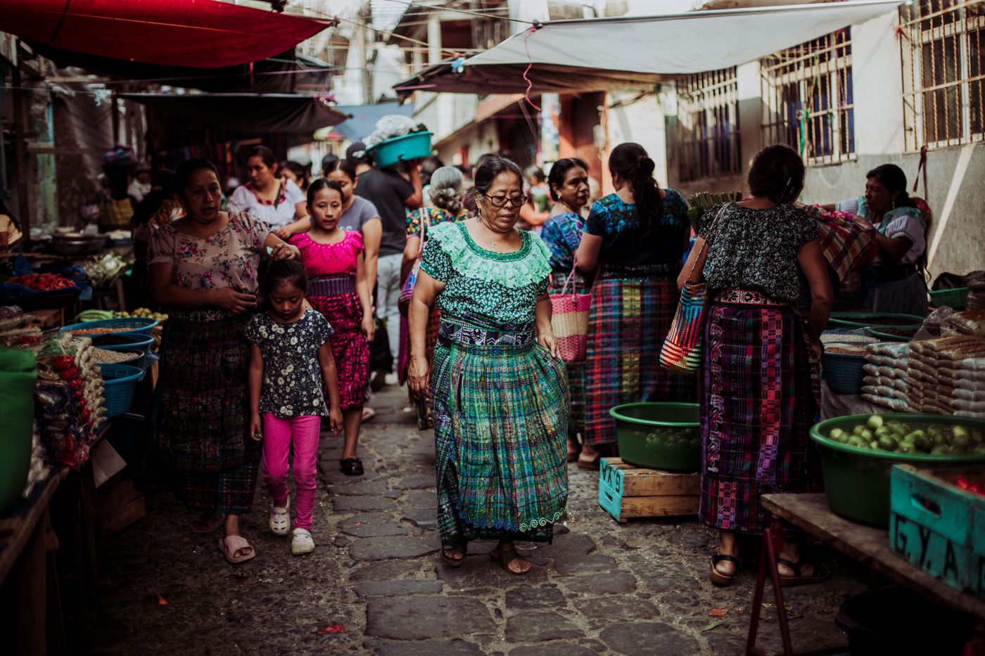 Familia con trajes tradicionales de colores en un mercado guatemalteco